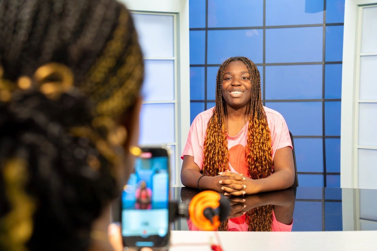 A student practices being at the anchor desk