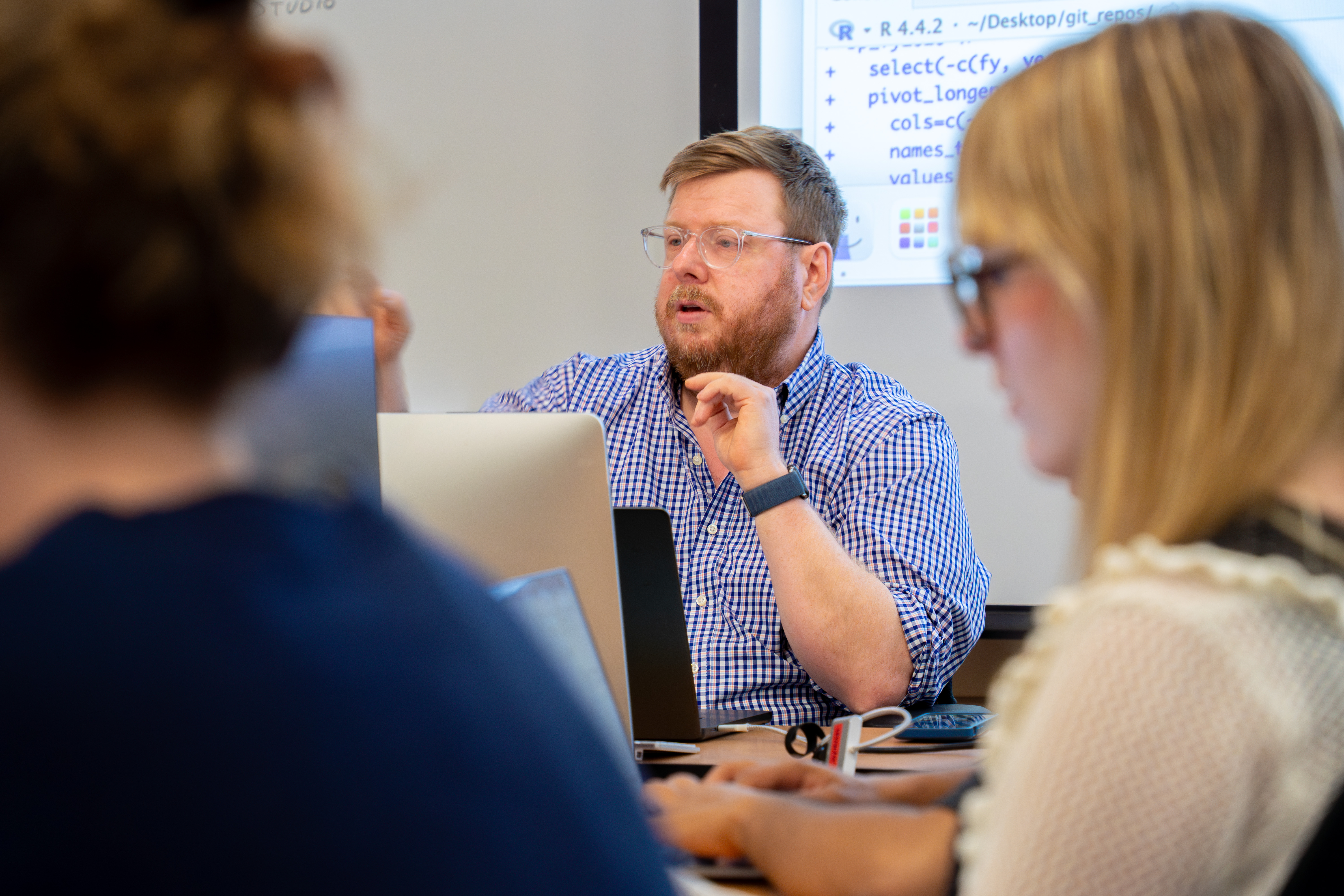 Sean Mussenden pointing as he teaches students with data on the screen behind him