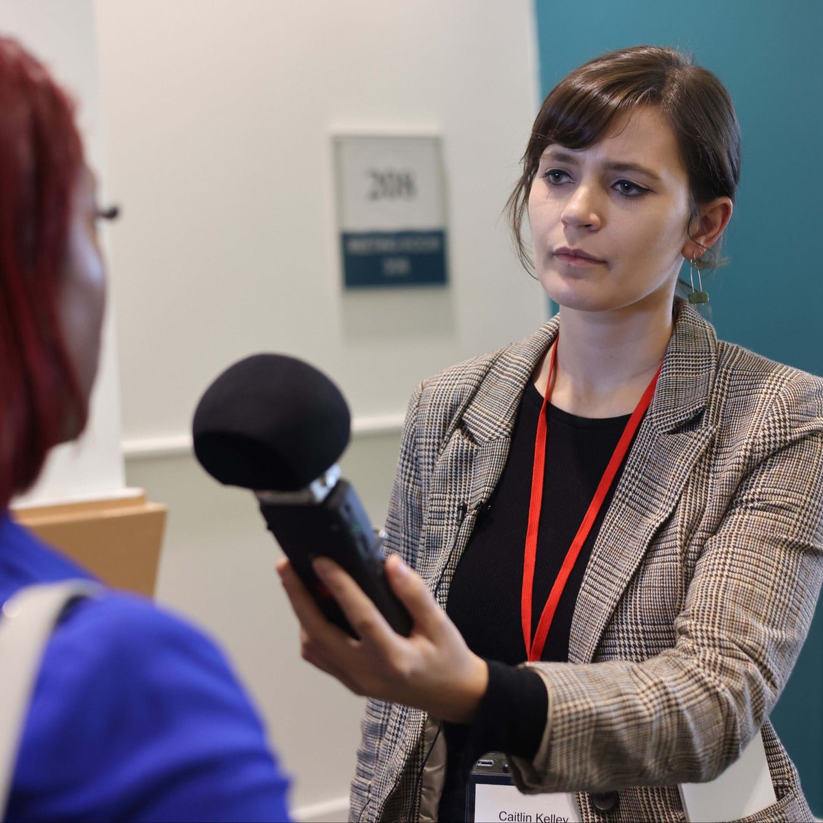Student reporter with microphone raised during one-on-one interview