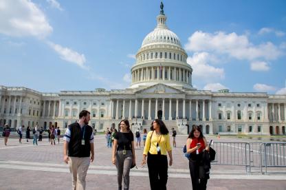 One man student and three women student walking away from the Capitol in D.C.