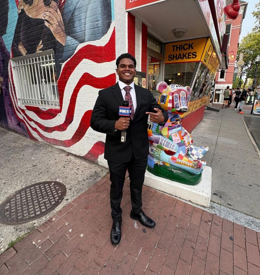 Intern for Fox 5 DC Isaiah Woodley, outside in D.C. with a microphone