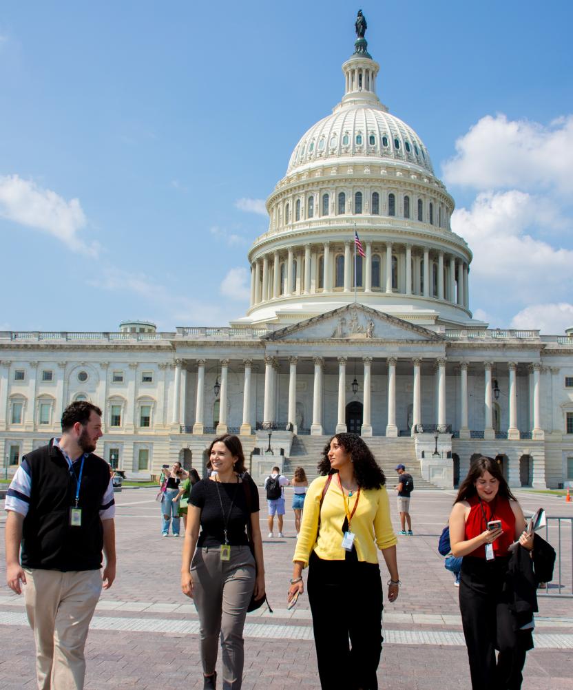 Four Capital News Service reporters smiling and talking as they walk away from the Capitol in D.C.