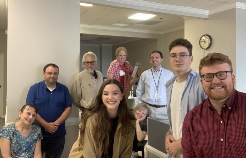 Katie Wilson, center, in a smiling group shot with six men and one woman in the Hagerstown Herald-Mail newsroom.