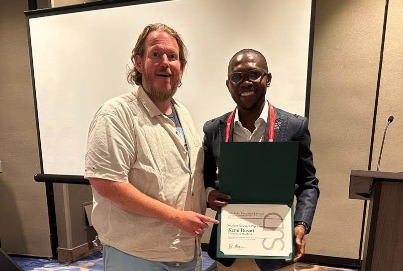 Kemi Busari presented with an award at the AEJMC conference.