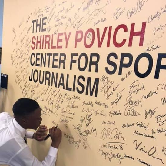 Alumnus Daniel Oyefusi signs the Povich Center wall.