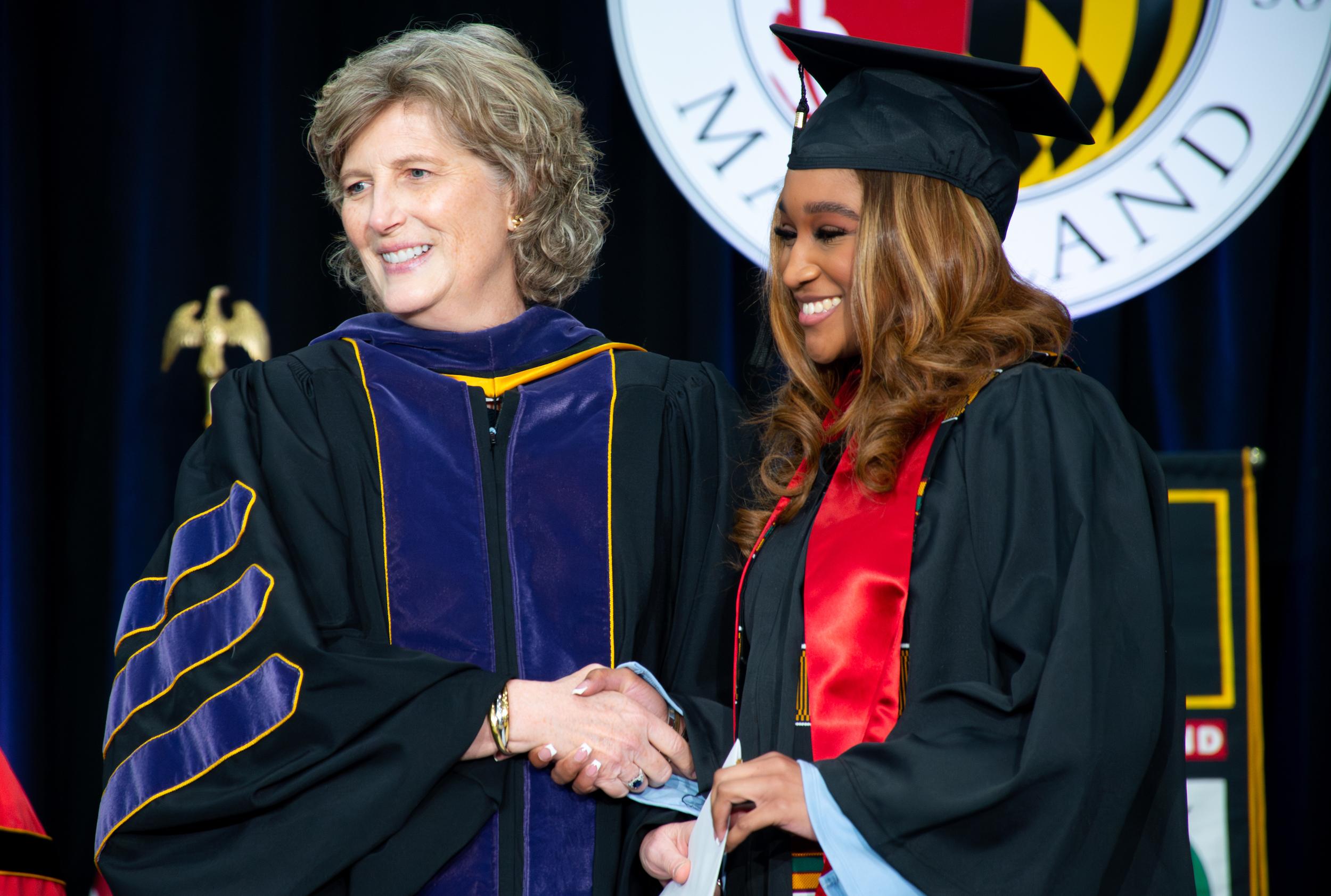 Lucy Dalglish and student walking across stage