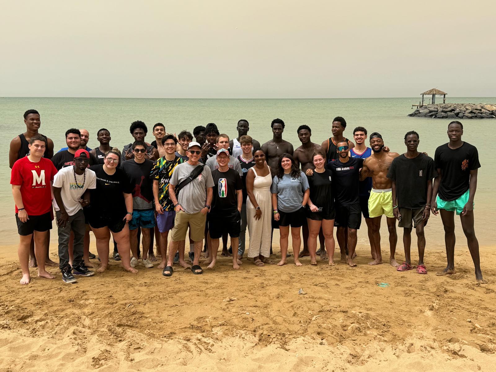 Students and advisors with African basketball players at the beach