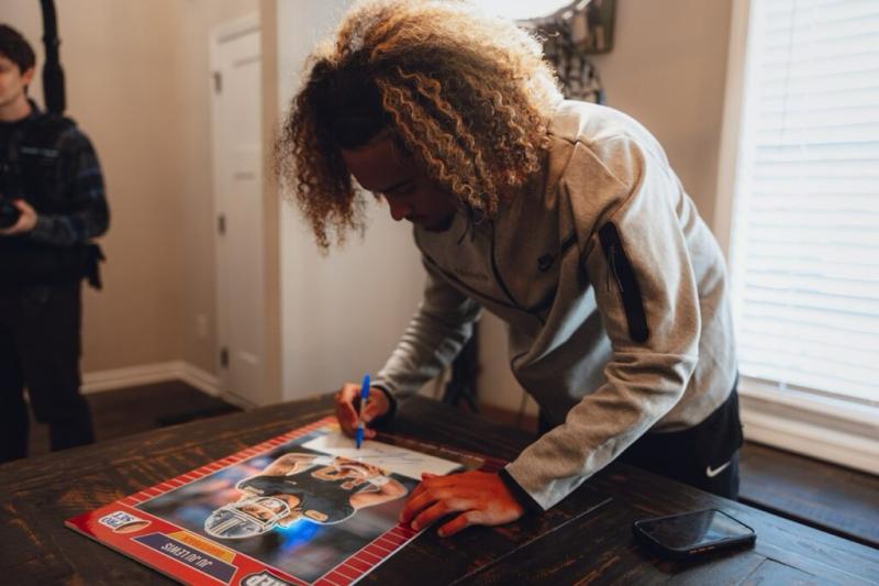 Julian “JuJu” Lewis signs a jumbo version of his own Leaf Trading Card